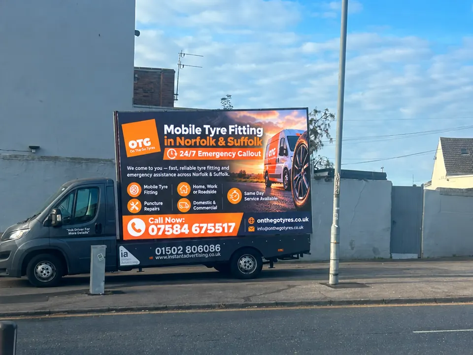 The digivan parked at the roadside showing an advert for On the Go Tyres mobile tyre fitting