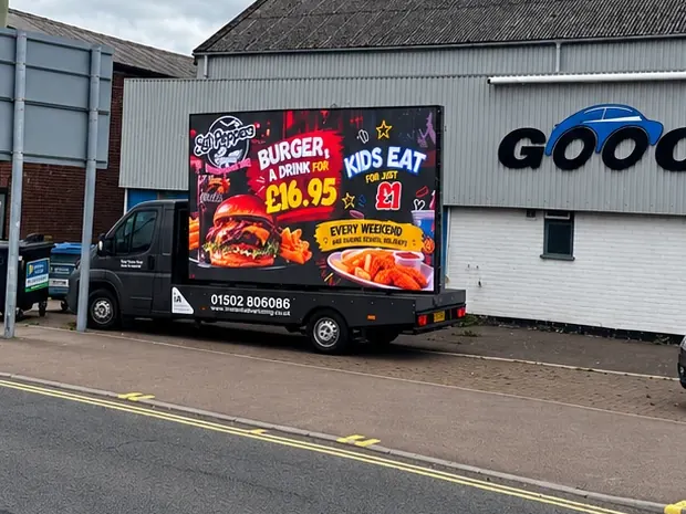 The digivan parked at the roadside, showing an SGT Peppers advert for burger meal deals and kids eating for £1